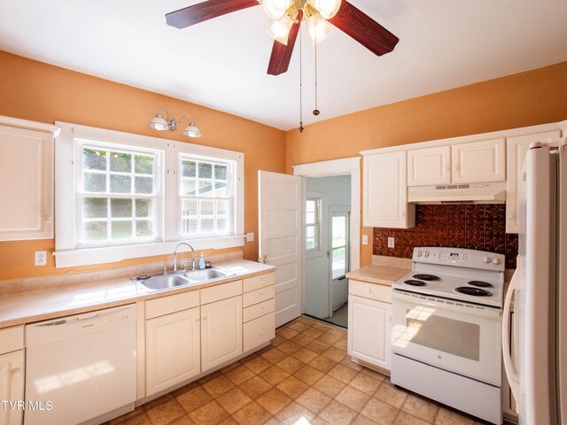 kitchen featuring a wealth of natural light, white appliances, ceiling fan, and wall chimney range hood