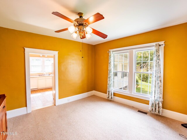 tiled spare room with ceiling fan