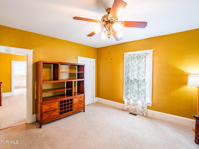 bedroom featuring light colored carpet, a closet, and ceiling fan