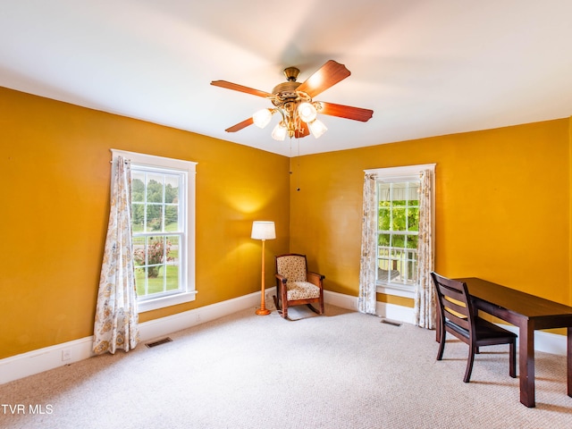 carpeted office space with ceiling fan