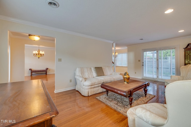 living room with a notable chandelier, light hardwood / wood-style flooring, and crown molding