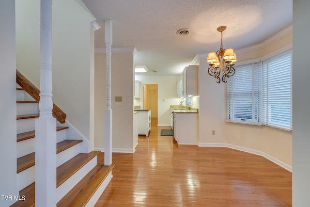 interior space featuring a wealth of natural light, a textured ceiling, light hardwood / wood-style floors, and a chandelier