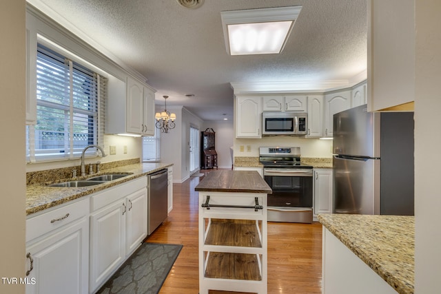 kitchen featuring light wood-type flooring, sink, stainless steel appliances, and white cabinets