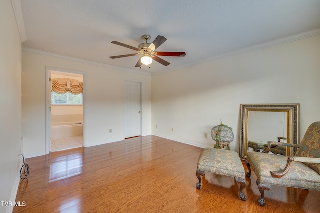 sitting room with ceiling fan, a textured ceiling, crown molding, and light hardwood / wood-style floors