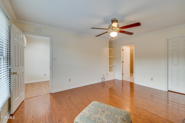 empty room with ceiling fan, hardwood / wood-style floors, and crown molding