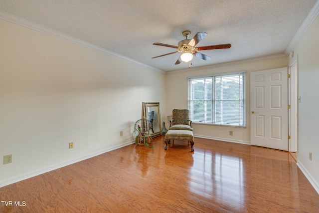 living area with ceiling fan, crown molding, a textured ceiling, and light hardwood / wood-style floors