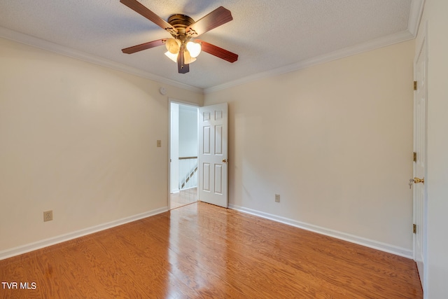 empty room with ceiling fan, light wood-type flooring, a textured ceiling, and crown molding