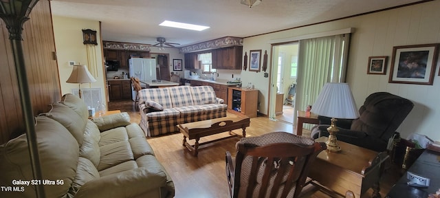 living room with ceiling fan, light wood-type flooring, and visible vents