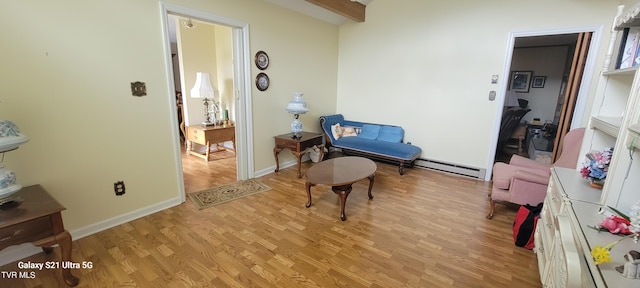 sitting room with light wood finished floors, a baseboard radiator, and baseboards