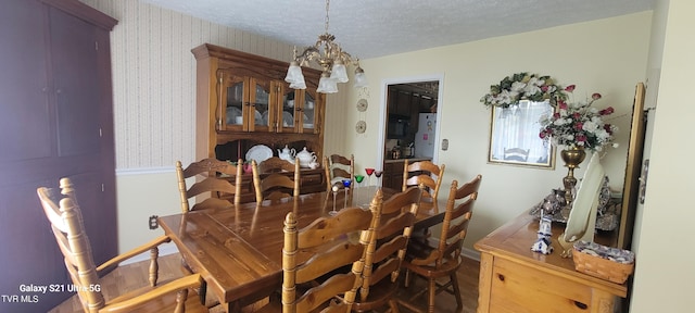 dining room with a textured ceiling and wallpapered walls