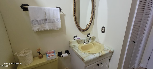 bathroom featuring a closet, vanity, and toilet