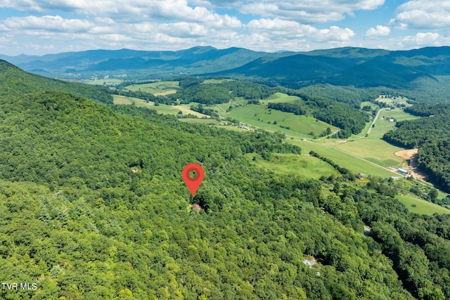 aerial view featuring a wooded view and a mountain view