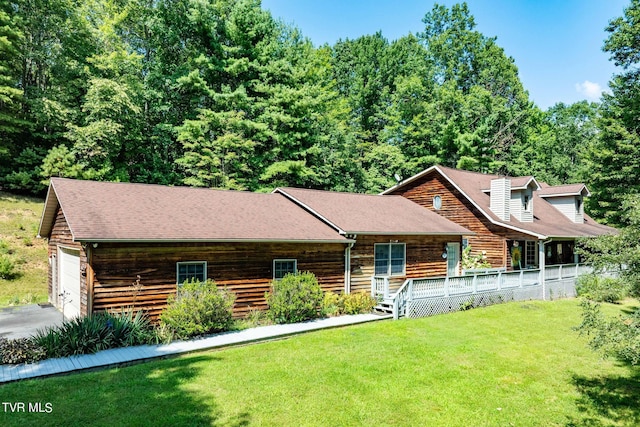 log cabin featuring a garage and a front lawn