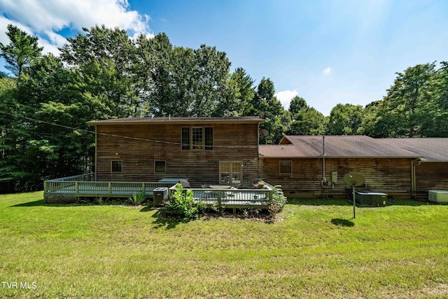 back of property featuring a lawn and a wooden deck