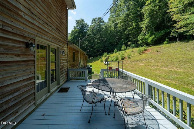 wooden deck with a yard and outdoor dining space