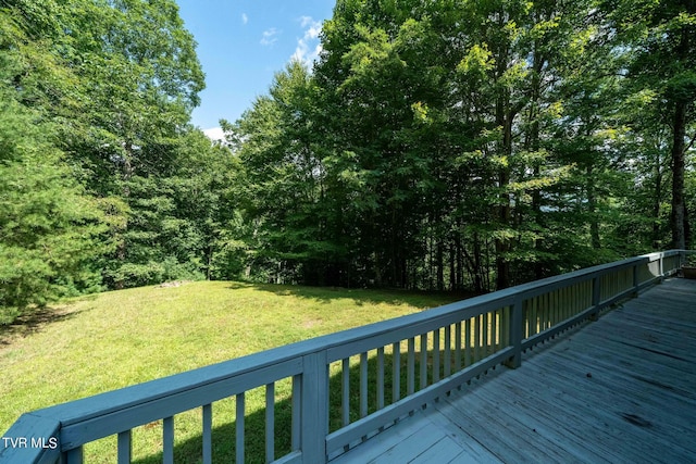 wooden terrace featuring a lawn