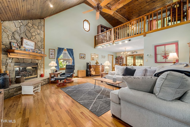 living area with wood ceiling, a stone fireplace, and wood finished floors