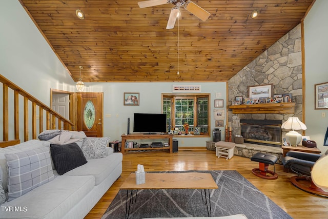 living room with wooden ceiling, wood finished floors, stairs, a fireplace, and high vaulted ceiling