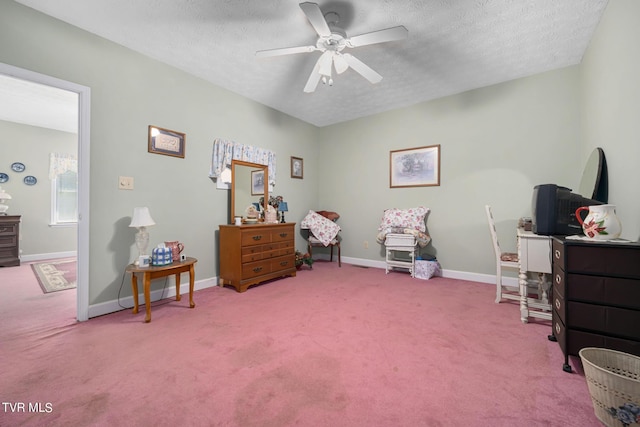 interior space featuring ceiling fan, baseboards, a textured ceiling, and carpet flooring