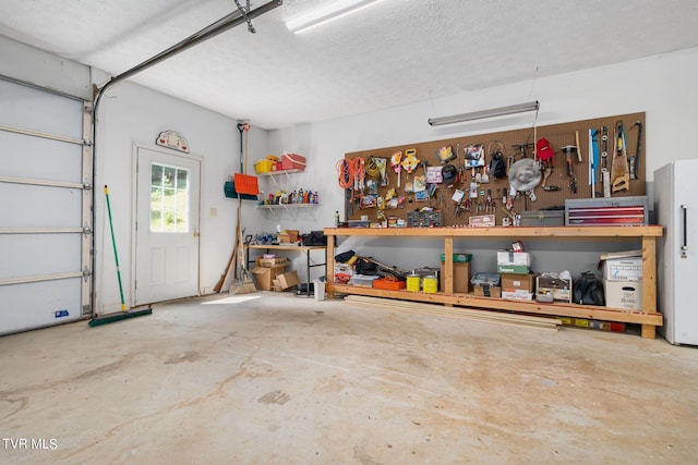 garage with a workshop area and freestanding refrigerator