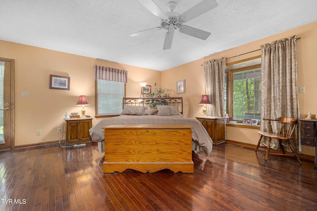 bedroom featuring a textured ceiling, wood-type flooring, a ceiling fan, and baseboards