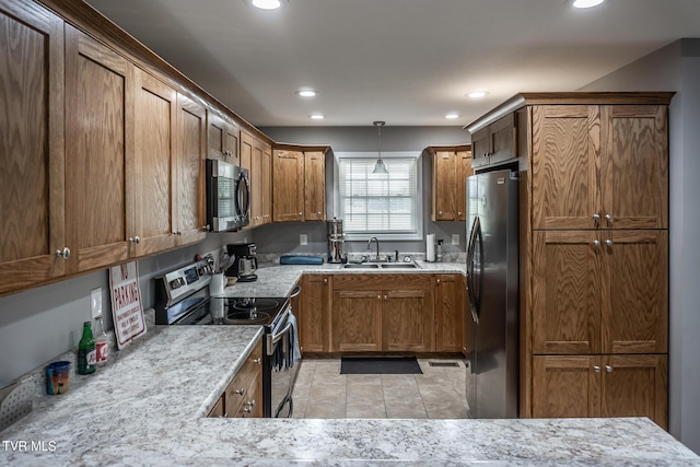 kitchen with brown cabinets, decorative light fixtures, stainless steel appliances, a sink, and recessed lighting