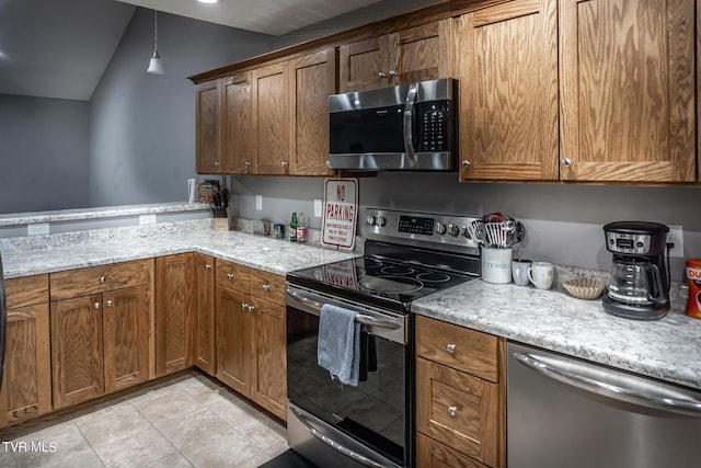 kitchen with a peninsula, appliances with stainless steel finishes, and brown cabinets