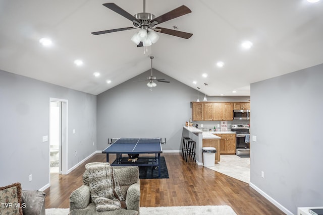 recreation room featuring lofted ceiling, baseboards, wood finished floors, and recessed lighting