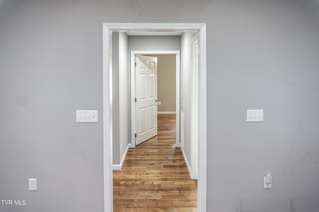 hall featuring wood finished floors and baseboards