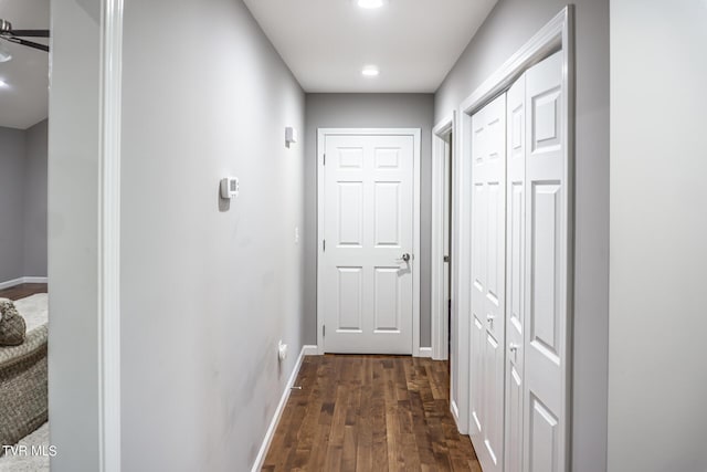 corridor featuring dark wood-style floors and baseboards