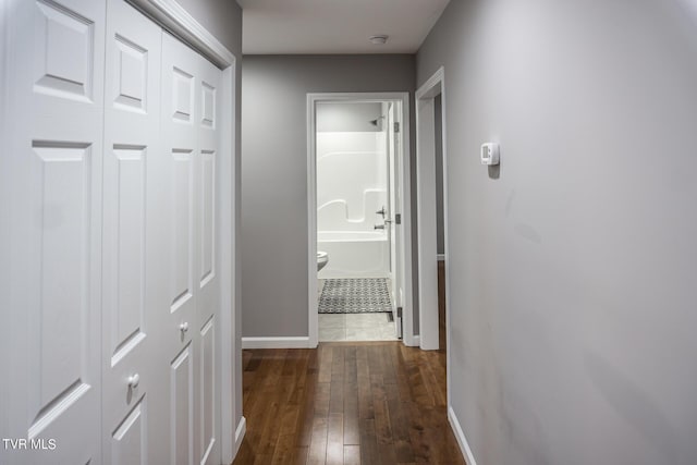 hallway with dark wood-style floors and baseboards