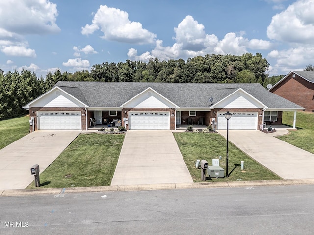 ranch-style house with concrete driveway, brick siding, and a front lawn