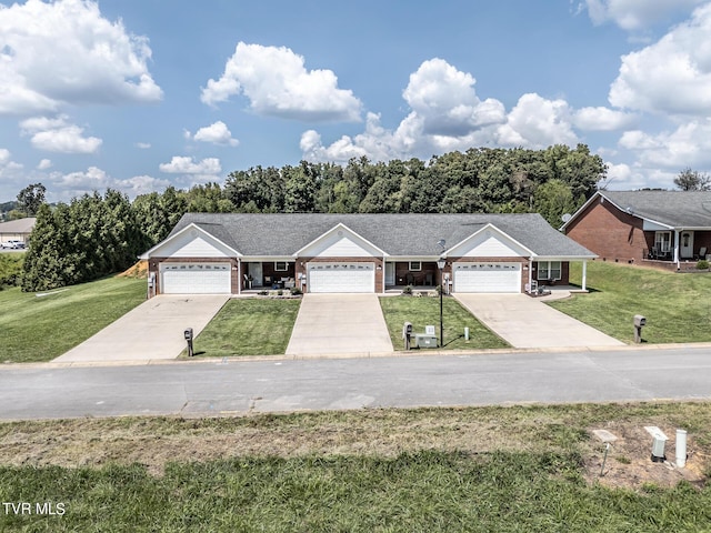 ranch-style home with a garage, concrete driveway, and a front yard