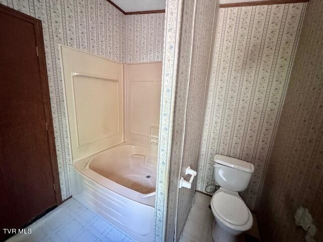 bathroom with a bathtub, toilet, and tile patterned floors