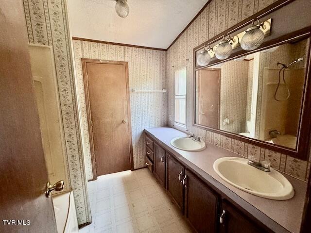 bathroom with vaulted ceiling, shower / bathing tub combination, tile patterned floors, and vanity