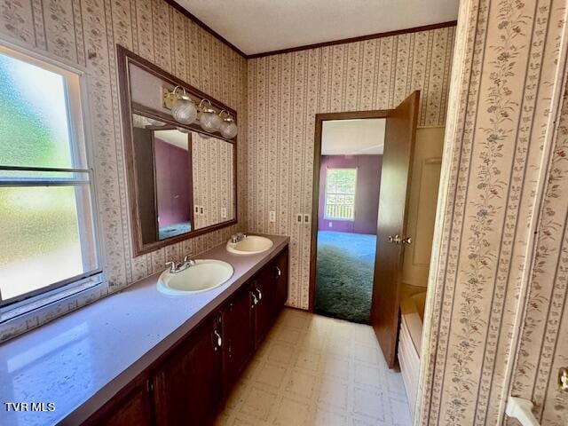 bathroom featuring tile patterned flooring, crown molding, a tub to relax in, and vanity