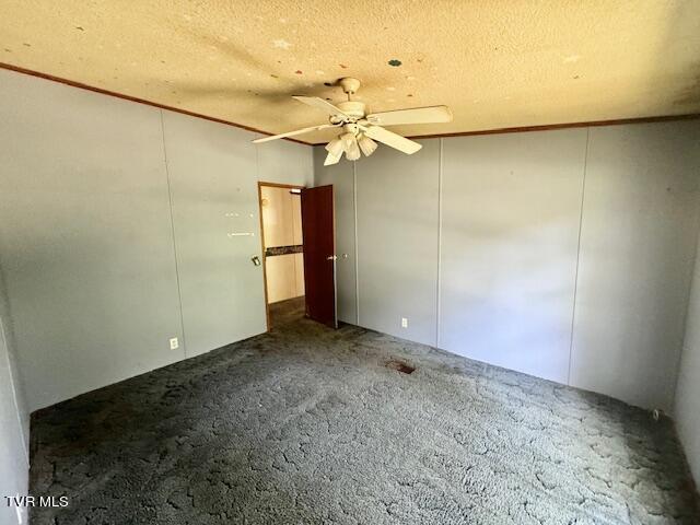 carpeted spare room with ceiling fan and a textured ceiling