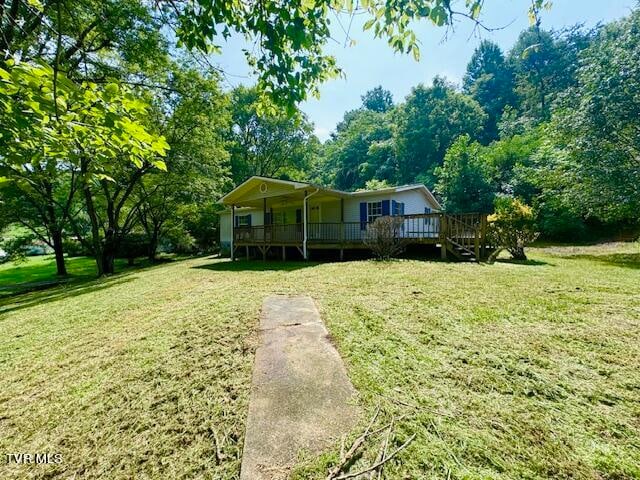 view of front facade featuring a front lawn and a wooden deck