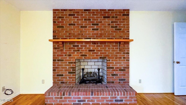 details featuring hardwood / wood-style floors and a brick fireplace