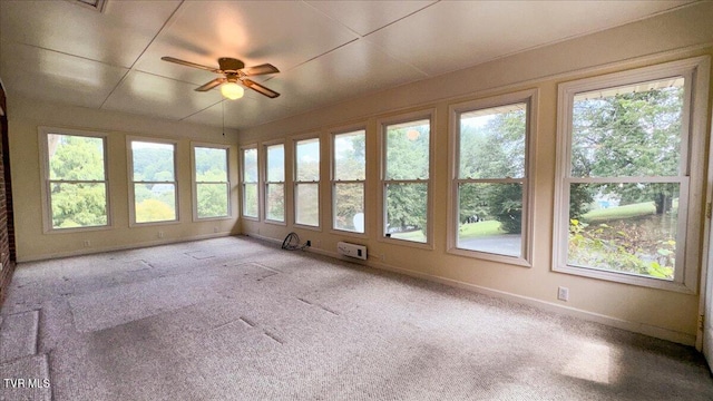 unfurnished sunroom featuring a paneled ceiling, ceiling fan, and plenty of natural light