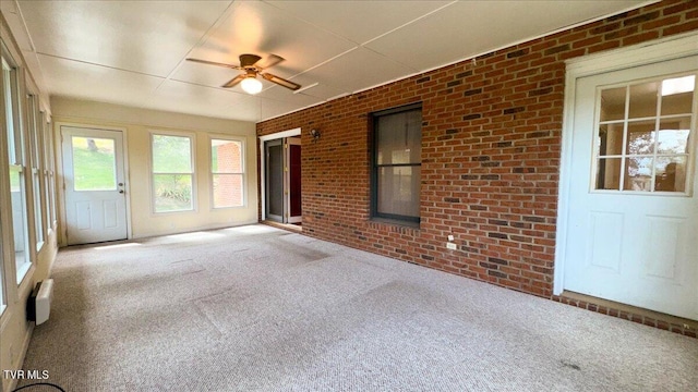 unfurnished sunroom featuring ceiling fan