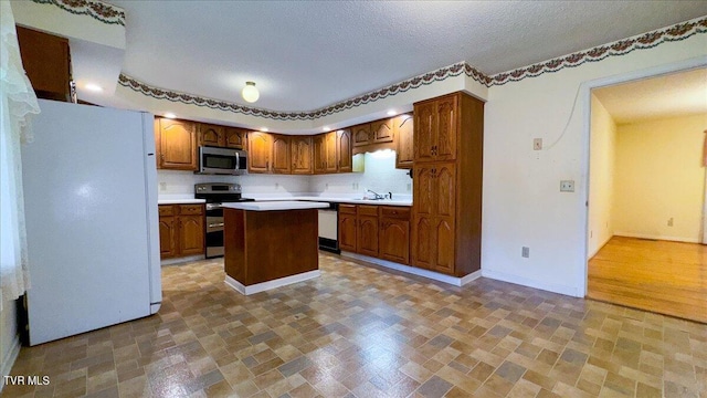 kitchen with a textured ceiling, dark hardwood / wood-style floors, a center island, stainless steel appliances, and sink