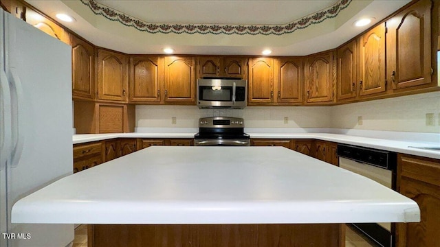 kitchen with a center island, appliances with stainless steel finishes, and decorative backsplash