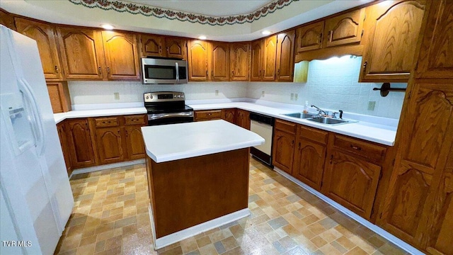 kitchen with a kitchen island, stainless steel appliances, sink, and decorative backsplash