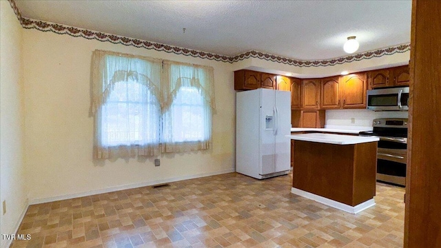 kitchen featuring light tile patterned floors, a kitchen island, and stainless steel appliances