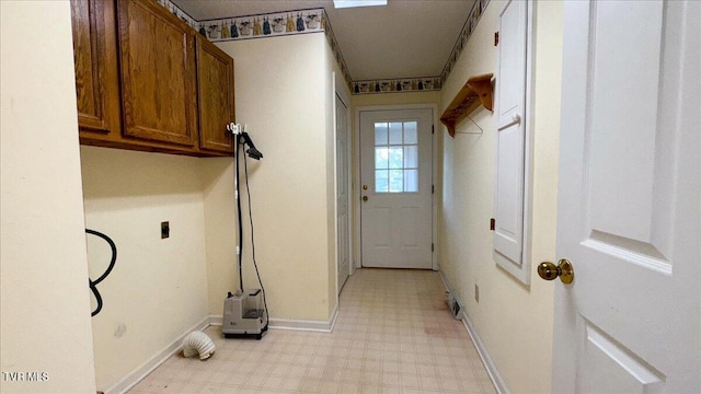 laundry room with hookup for an electric dryer, cabinets, and light tile patterned flooring