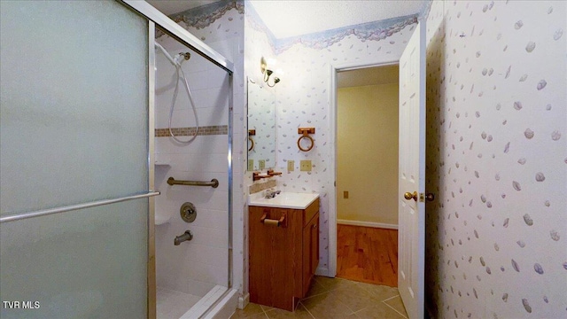 bathroom featuring tile patterned flooring, vanity, and walk in shower