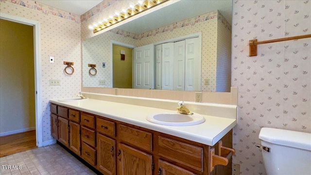 bathroom with tile patterned flooring, vanity, and toilet