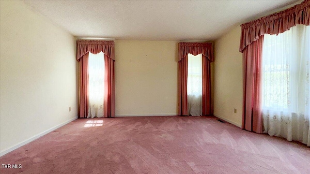 carpeted spare room with a textured ceiling