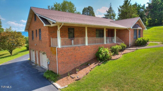 ranch-style house with covered porch, a garage, and a front lawn